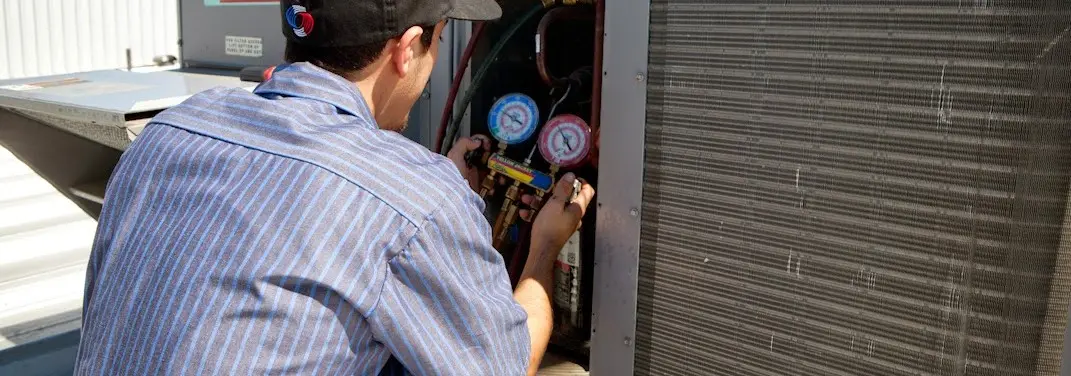 HVAC technician servicing a condenser unit in Goleta